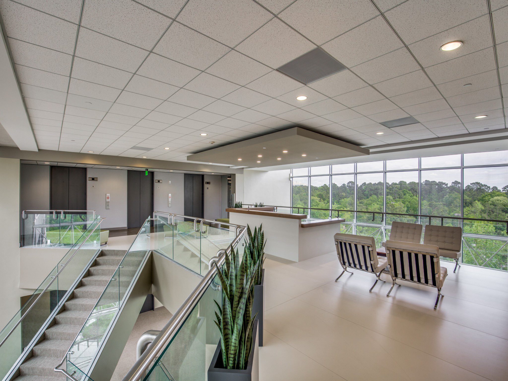 A professional workspace with a glass wall and a big desk.